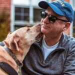 Man and his dog share a loving moment outdoors, showcasing friendship and joy.